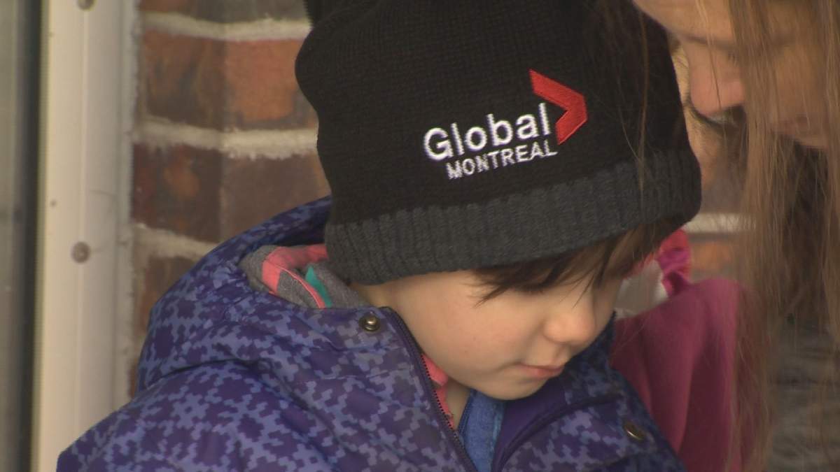 Charlotte Kuhn wears a Global News tuque while her family collects money for speech therapy at Saint-Henri Metro, Wednesday, October 26, 2016.