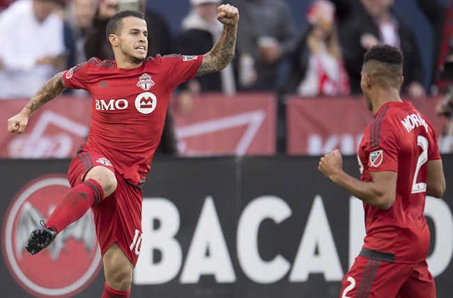 Toronto FC's Sebastian Giovinco celebrates his penalty kick goal with teammate Justin Morrow (right) against the Chicago Fire during first half MLS soccer action in Toronto, Sunday, October 23, 2016. Toronto FC has been waiting for a home playoff game for almost a decade. THE CANADIAN PRESS/Frank Gunn.