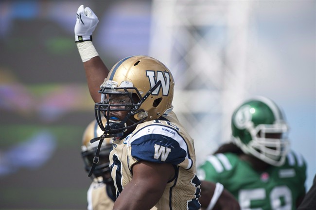 The Saskatchewan Roughriders signed national linebacker Henoc Muamba on Wednesday. Muamba, in Bombers colours, celebrates a tackle against the Saskatchewan Roughriders during CFL football action in Regina in a September 1, 2013, file photo.