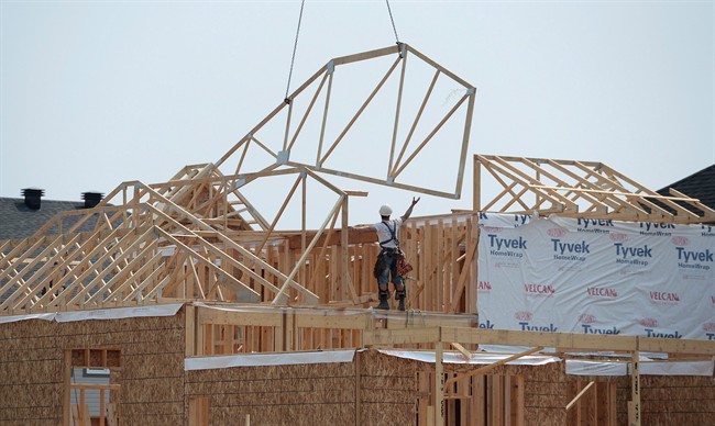 Construction workers build new homes in a development in Ottawa on Monday, July 6, 2015. 