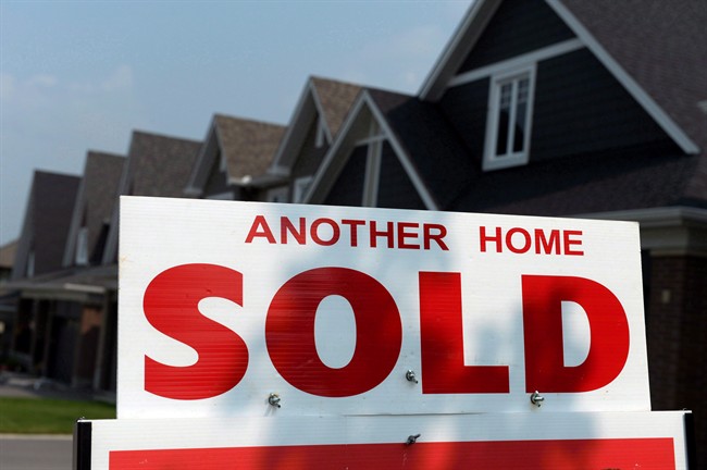 A for sale sign displays a sold home in a development in Ottawa on July 6, 2015.