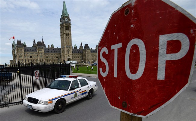 An RCMP cruiser drives past a stop sign on Parliament Hill in Ottawa on Thursday, June 13, 2013.