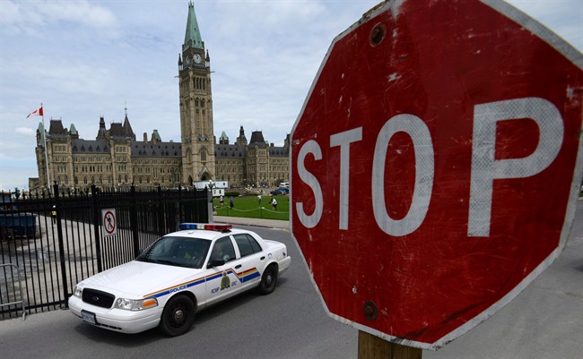 An RCMP cruiser drives past a stop sign on Parliament Hill in Ottawa on Thursday, June 13, 2013. 