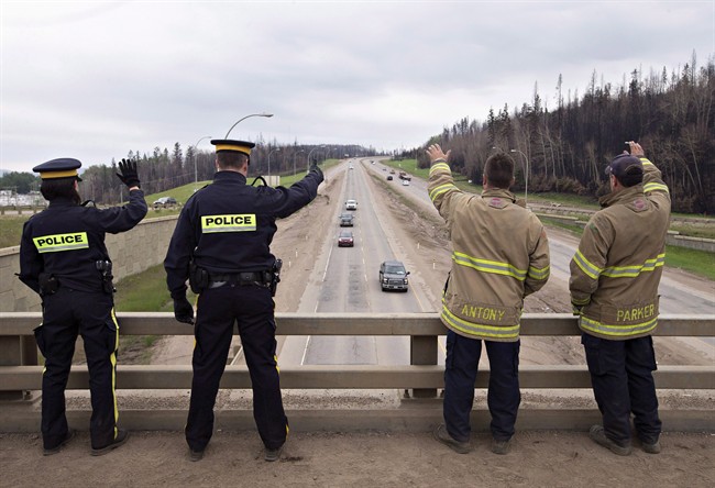 Firefighters and police welcome people into Fort McMurray Alta, on Wednesday June 1, 2016. 