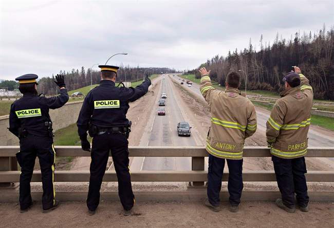 Firefighters and police welcome people into Fort McMurray Alta, on Wednesday June 1, 2016. Premier Rachel Notley and her government paid tribute Monday to those who came to Alberta's aid and rescue during the spring's devastating Fort McMurray wildfire.