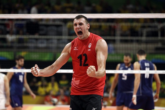 Canada's Gavin Schmitt celebrates a win after a men's preliminary volleyball match against Italy at the 2016 Summer Olympics in Rio de Janeiro, Brazil, Monday, Aug. 15, 2016. Canadian men's volleyball star Schmitt has announced his retirement from the national team after helping the country to a quarter-final berth at the Olympic Games.