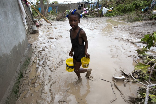 A girl lugs buckets of drinking water after the passing of Hurricane Matthew in Les Cayes, Haiti, Thursday, Oct. 6, 2016. Two days after the storm rampaged across the country’s remote southwestern peninsula, authorities and aid workers still lack a clear picture of what they fear is the country’s biggest disaster in years. (AP Photo/Dieu Nalio Chery)