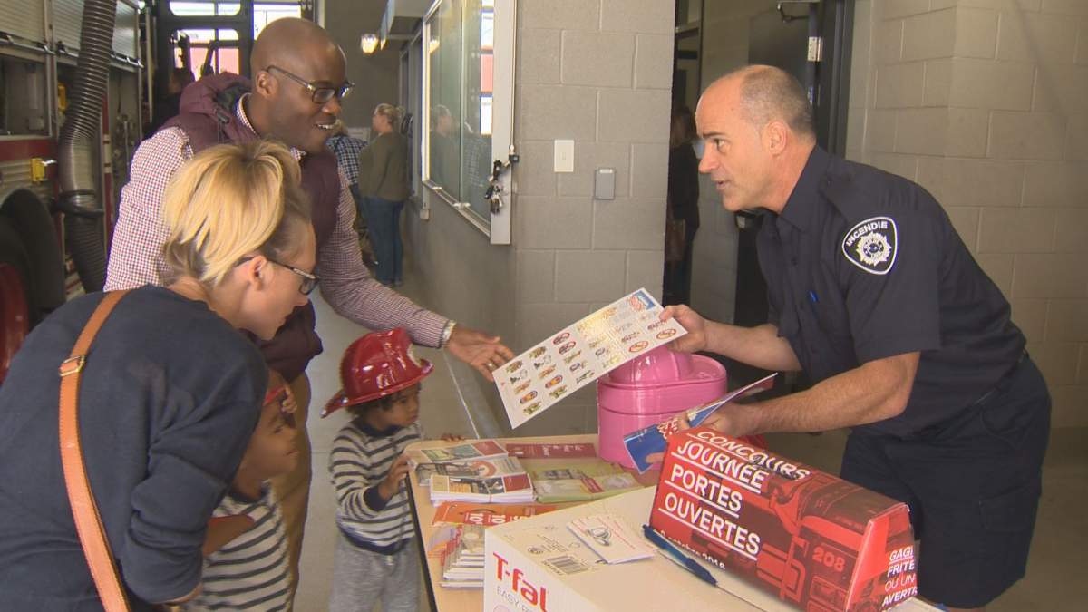 A firefighter promotes fire safety during an open house at the Sainte-Dorothee fire station in Laval on Sun. Oct. 9, 2016.