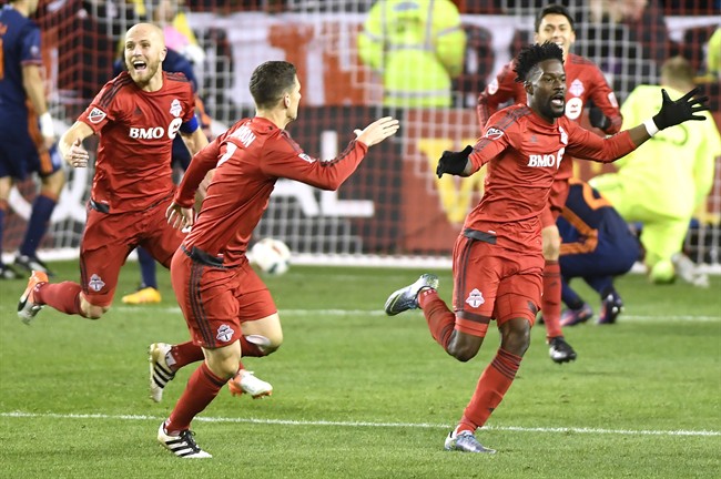 Toronto FC forward Tosaint Ricketts (87), right to left, celebrates his goal with teammates Will Johnson (7) and Michael Bradley (4) during second half MLS soccer playoff action against New York City FC in Toronto, Sunday, October 30, 2016. THE CANADIAN PRESS/Frank Gunn.