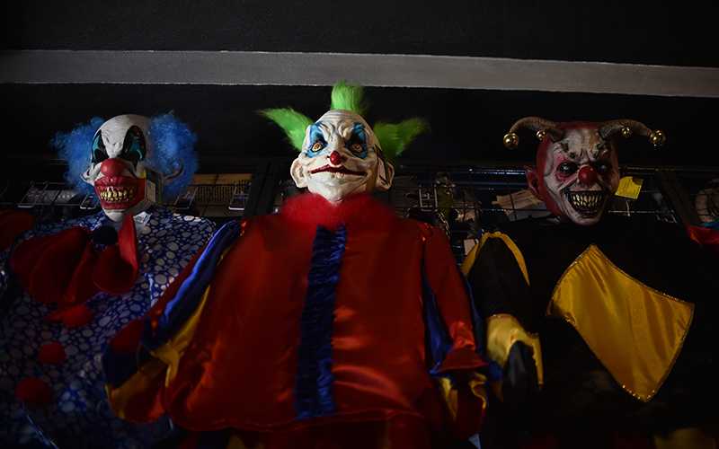 Clown costumes are displayed for sale at a costume shop.