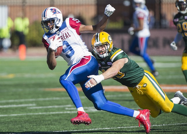 Kenny Stafford is tackled by Edmonton Eskimos' Neil King during a CFL game in Montreal on Oct. 10, 2016. 