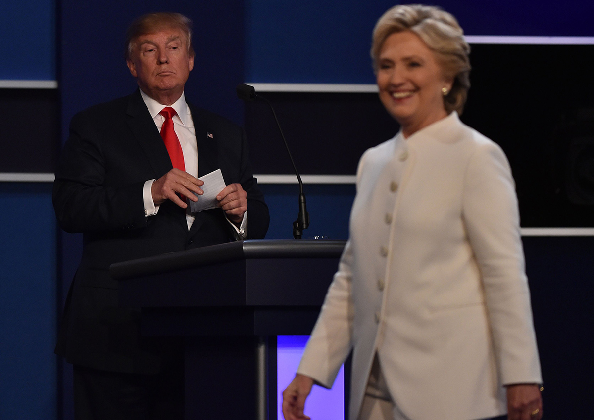 Democratic presidential nominee Hillary Clinton departs the stage following the third and final US presidential debate with Republican nominee Donald Trump (background) at the Thomas & Mack Center on the campus of the University of Las Vegas in Las Vegas, Nevada on October 19, 2016. 