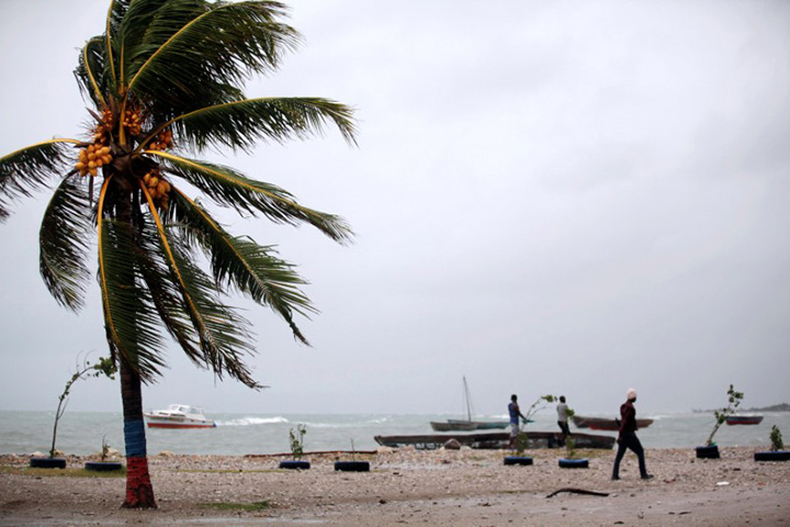 Residents walk next to anchored boats as Hurricane Matthew approaches in Les Cayes, Haiti, October 3, 2016. 