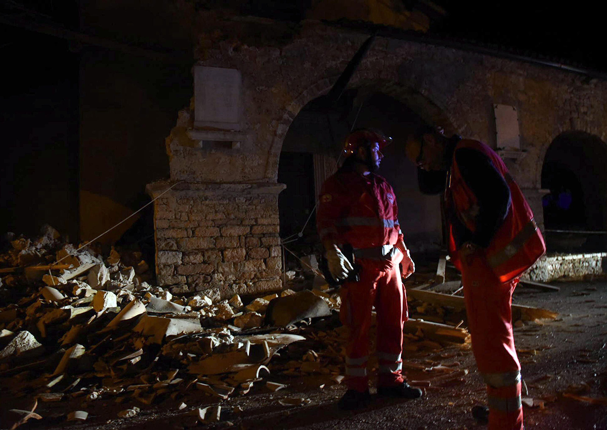 Rescuers stand by rubble in the village of Visso, central Italy, Wednesday, Oct. 26, 2016 following an earthquake. A pair of powerful aftershocks shook central Italy on Wednesday, knocking out power, closing a major highway and sending panicked residents into the rain-drenched streets just two months after a powerful earthquake killed nearly 300 people.