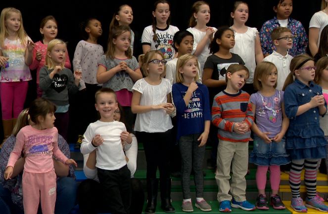 Jaxon, 8, smiles at the camera as he sings during choir.