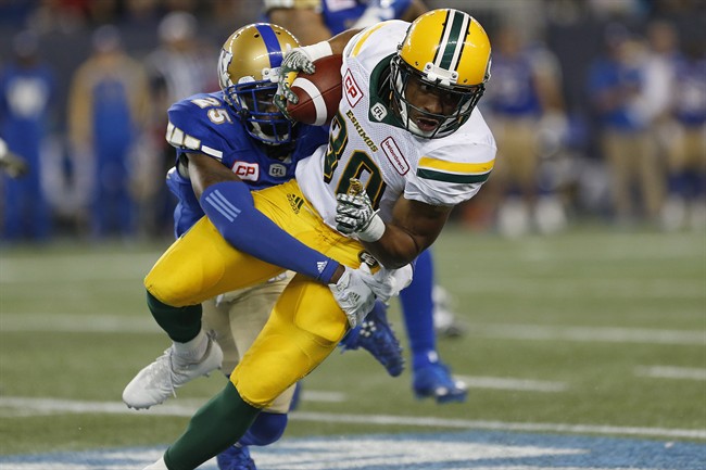 Edmonton Eskimos' John White gets wrapped up by Winnipeg Blue Bombers' Bruce Johnson during the first half of a CFL game in Winnipeg on Friday, September 30, 2016.