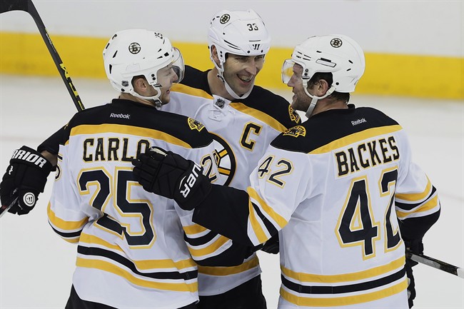 Boston Bruins' Brandon Carlo (25), Zdeno Chara (33) and David Backes (42) celebrate Chara's empty net goal against the Winnipeg Jets during third period NHL action in Winnipeg on Monday, October 17.