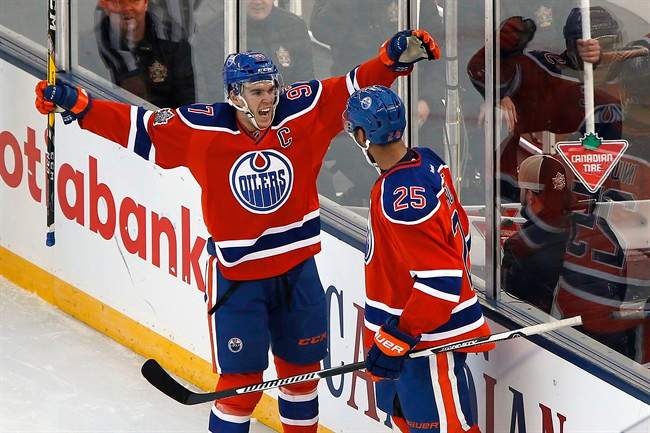 Edmonton Oilers' Darnell Nurse (25) and Connor McDavid (97) celebrate Nurse's goal against the Winnipeg Jets during second period NHL Heritage Classic action in Winnipeg on Sunday, October 23, 2016.