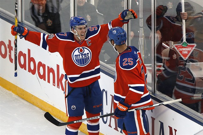 Edmonton Oilers' Darnell Nurse (25) and Connor McDavid (97) celebrate Nurse's goal against the Winnipeg Jets during second period NHL Heritage Classic action in Winnipeg on Sunday, October 23, 2016.