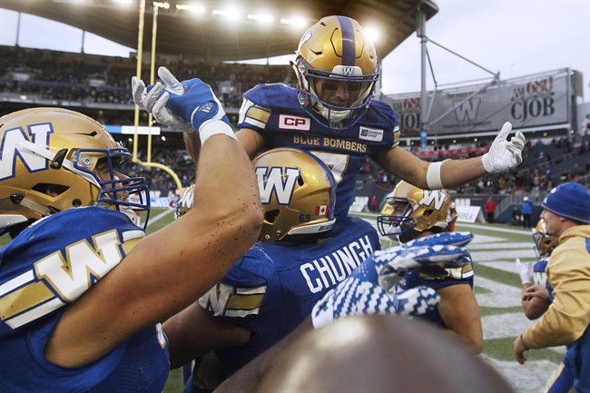 Winnipeg Blue Bombers players raise Weston Dressler (7) after he ran around the end zone burning off precious time in the dying seconds of the second half of CFL action against the B.C. Lions in Winnipeg Saturday, October 8, 2016. 