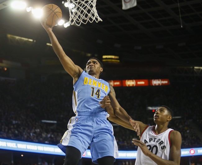 Denver Nuggets' Gary Harris, left, takes the ball to the basket as Toronto Raptors' Bruno Caboclo, looks on during first half NBA pre-season basketball action in Calgary, Alta., Monday, Oct. 3, 2016. 