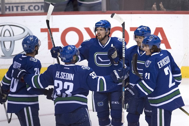 Vancouver Canucks left wing Daniel Sedin (22) celebrates his goal against the Buffalo Sabres with teammates Brandon Sutter (20), Henrick Sedin (33), Philip Larsen (63) and Loui Eriksson (21) during third period NHL action in Vancouver, B.C. Thursday, Oct. 20, 2016. 