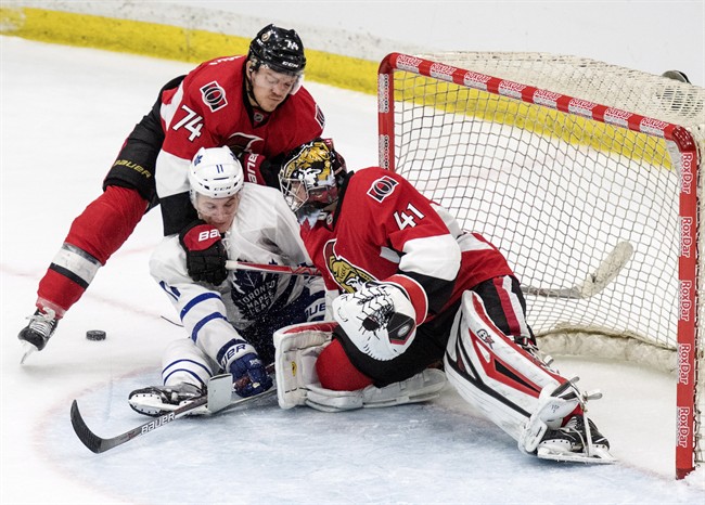 Ottawa Senators goalie Craig Anderson and Ottawa defenceman Mark Borowiecki tie up Toronto Maple Leafs forward Zach Hyman during the third period of an NHL pre-season hockey game in Saskatoon, Tuesday, October 4, 2016.