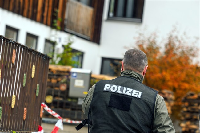 A policeman walks along the house in Georgensgmuend, Germany.