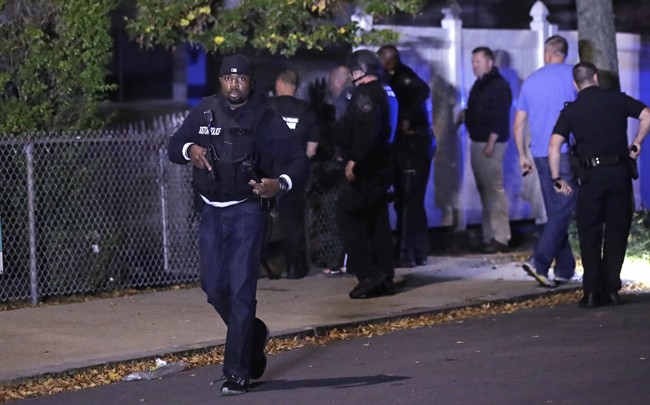 Police search for a suspect after a shooting in the East Boston neighborhood of Boston, Wednesday, Oct. 12, 2016. Police say two officers were shot late Wednesday night. Their conditions were not immediately available. It's unclear what led to the shooting. (AP Photo/Charles Krupa).
