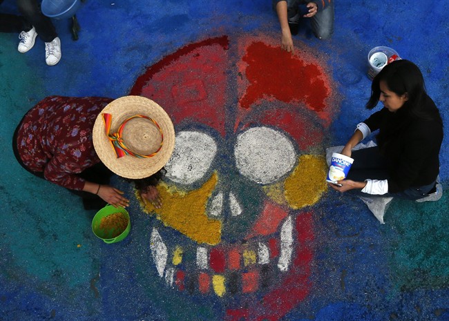 Residents create a sawdust representation of a skull during Day of the Dead festivities in Mexico City, Thursday, Oct. 27, 2016. The holiday honors the dead as friends and families gather in cemeteries to decorate their loved ones' graves and hold vigil through the night on Nov. 1 and 2. 