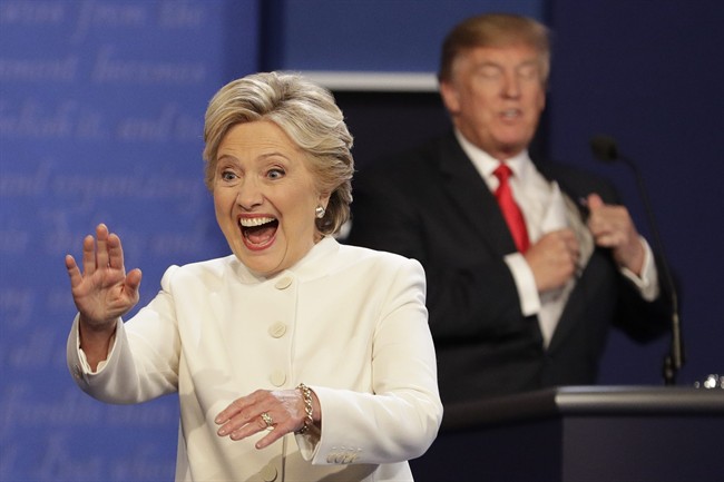 Democratic presidential nominee Hillary Clinton waves to the audience as Republican presidential nominee Donald Trump puts his notes away after the third presidential debate at UNLV in Las Vegas, Wednesday, Oct. 19, 2016.