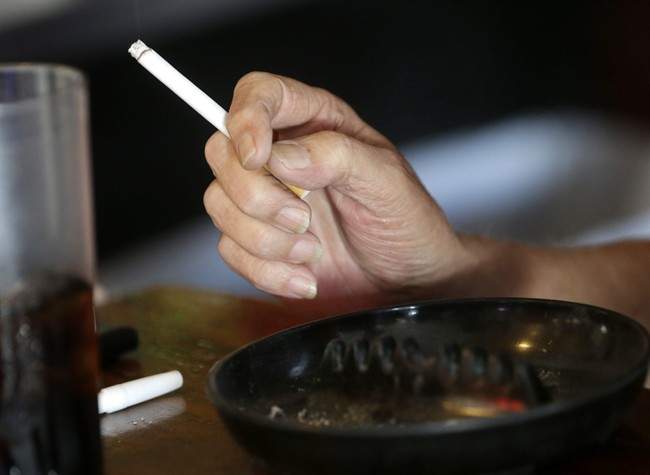 FILE:  A hand holds a  cigarette.