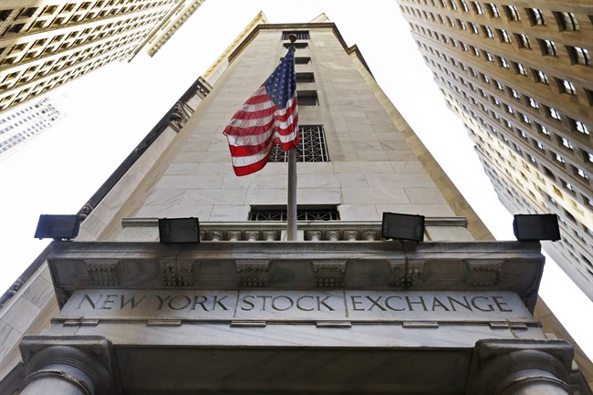 In this Friday, Nov. 13, 2015, file photo, the American flag flies above the Wall Street entrance to the New York Stock Exchange. 