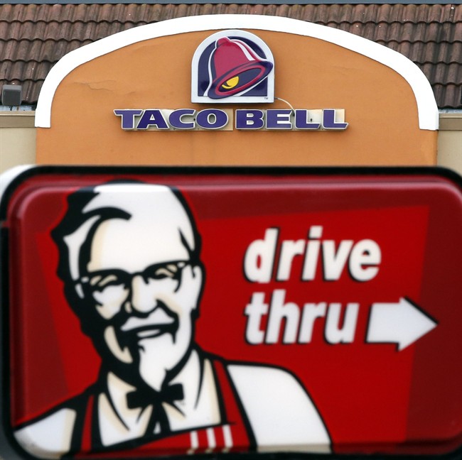 FILE - This Jan. 31, 2014, file photo, shows a Taco Bell facade behind a KFC drive-thru sign in Saugus, Mass. 