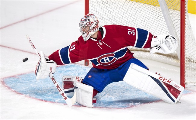 Montreal Canadiens goalie Carey Price deflects a shot as they face the Toronto Maple Leafs during first period of NHL pre-season hockey action Thursday, October 6, 2016 in Montreal. Price will miss the Canadiens NHL season opener with a flu, the team announced Wednesday, Oct. 12, 2016.