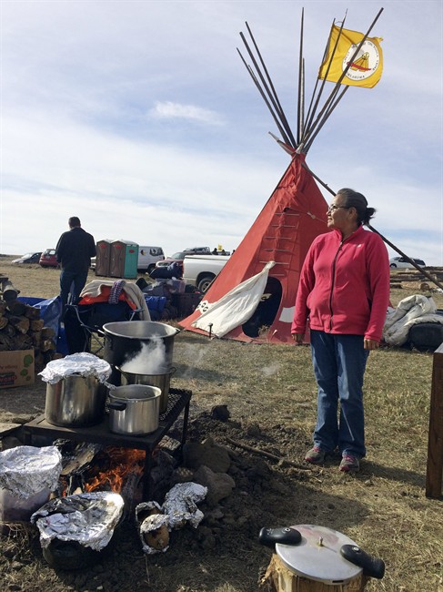 Mary Young Bear, of Tama, Iowa, cooks buffalo and potatoes over a campfire Monday, Oct. 24, 2016, at the Dakota Access oil pipeline protest in southern North Dakota. 
