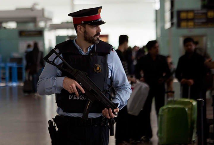 A police officer patrols an airport terminal in Barcelona, Spain, Tuesday, March 22, 2016. 