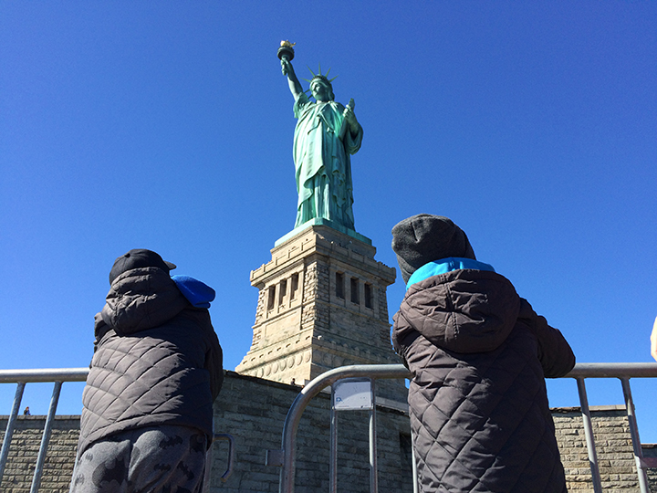 Kids admiring the beauty of the Statue of Liberty.