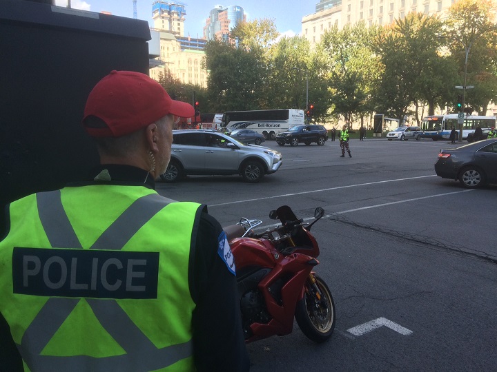 Police officers direct traffic in downtown Montreal as taxi drivers protesting Uber deal converge around Dorchester Square. Wednesday, Oct. 5, 2016.