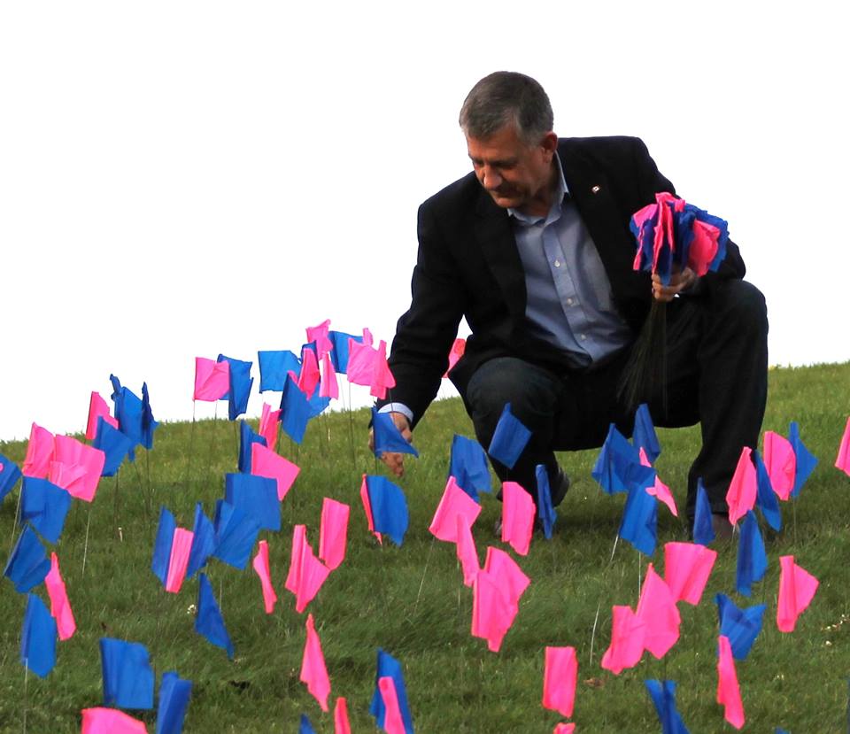 Ted Falk helps put up a pink and blue flag in Steinbach Saturday, saying each flag represents a life that was taken before it is born..