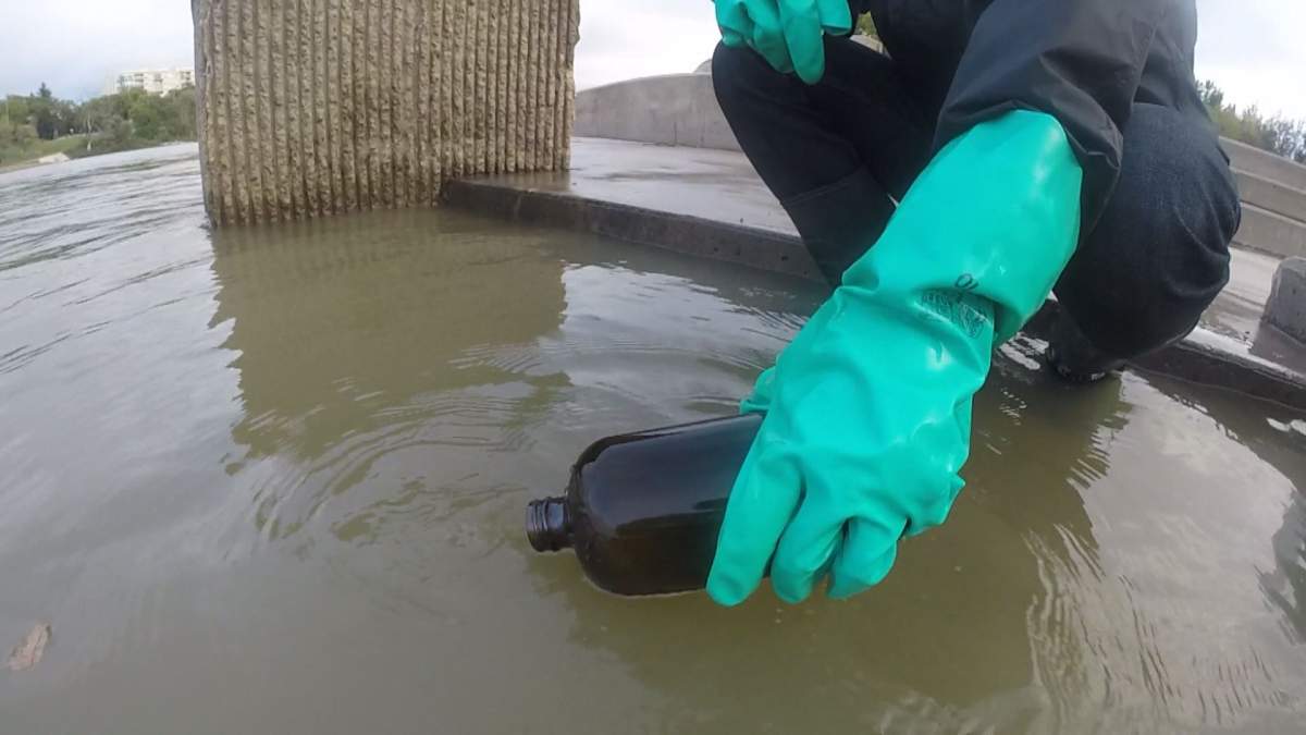 Global’s Adrian Cheung retrieving water from the Red River to be tested.
