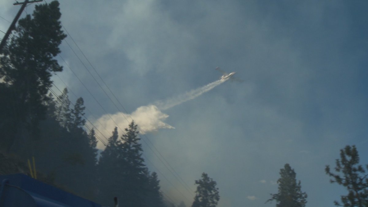 Skimmer plane drops water on Okanagan wildfire.