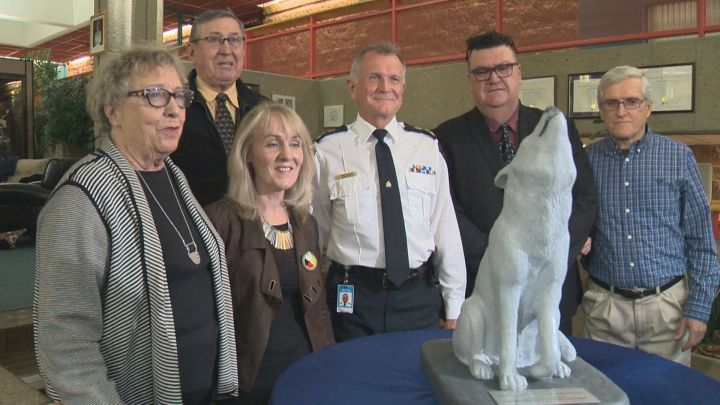 Edmonton Police Service Chief Rod Knecht (third from right) poses in front of a Wolf Award given to his police department.  The Wolf Project's Heather Acres is seen standing immediately next to Knecht.