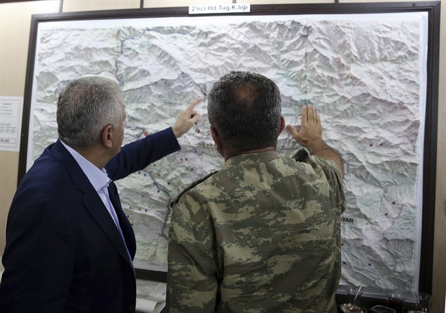 In this Monday, Sept. 5, 2016 photo, an army commander informs Turkey's Prime Minister Binali Yildirim, left, on a Turkey-Iraq border map, in Cukurca, Turkey. Iraq's Foreign Ministry has summoned Turkeys' ambassador to Baghdad over "provocative" comments by Turkish Prime Minister Binali Yildirim about the planned operation to dislodge Islamic State militants from the city of Mosul.