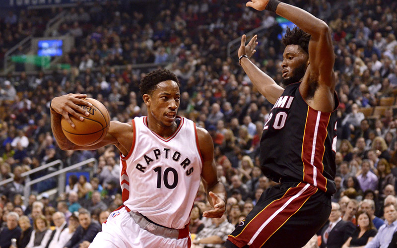 Toronto Raptors' DeMar DeRozan, left, drives to the net around Miami Heat's Justise Winslow during the first half of their NBA game on Friday, November 4, 2016 in Toronto.