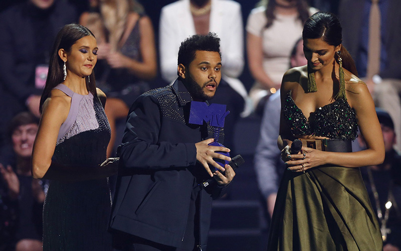 The Weeknd, centre, receives the Best Video Award from Nina Dobrev, left and Deepika Padukone, during the MTV European Music Awards 2016, in Rotterdam, Netherlands, Sunday, Nov. 6, 2016. 