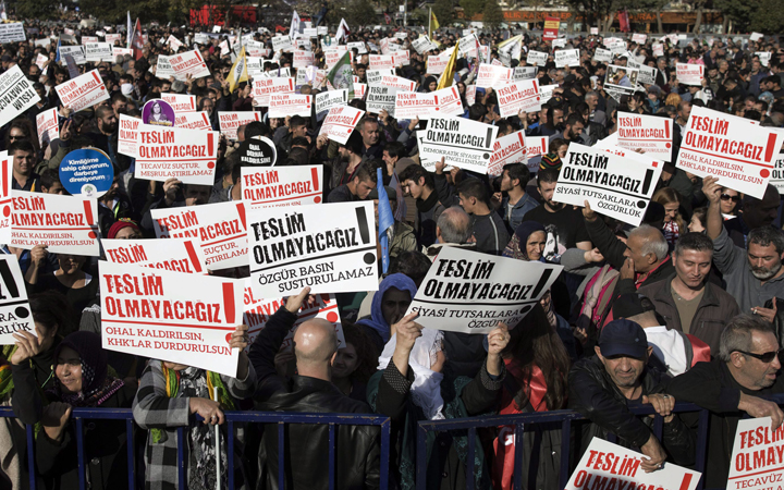 Thousands of people hold placards that read " We will not surrender! " as they stage an anti-government rally, condemning the arrests of opposition journalists, academics and politicians, in Asian side of Istanbul, Sunday, Nov. 20, 2016. 