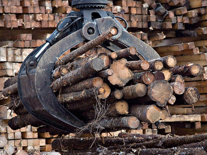 Workers pile logs at a softwood lumber sawmill in Saguenay, Que., on Nov. 14, 2008. 