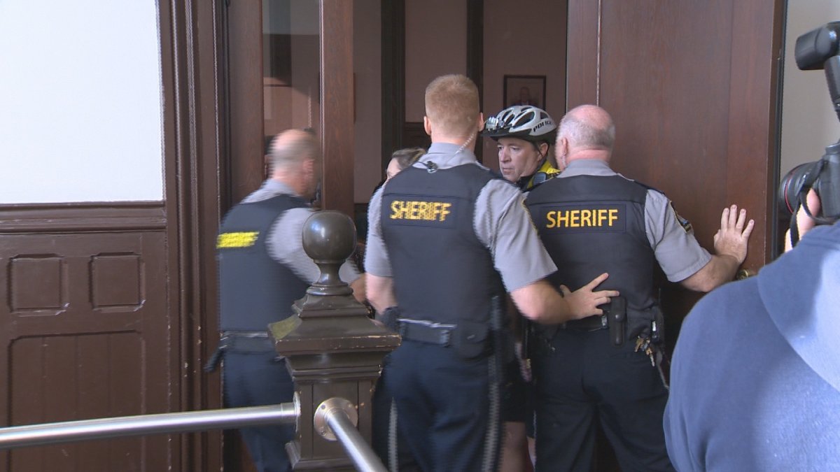 Sheriffs rush the door of a Halifax courtroom as chaos erupts after Carvel Clayton was escorted out. 
