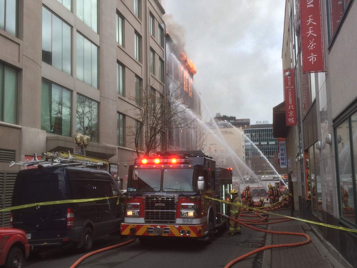 Firefighters battle a blaze in a building in Montreal's Chinatown, Thursday, November 17, 2016.